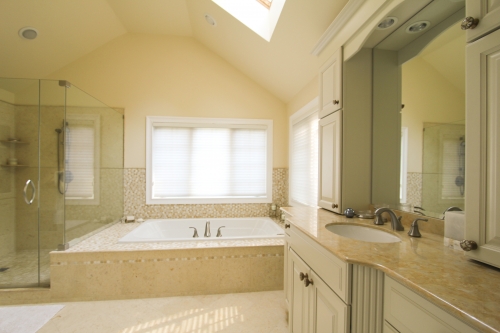Master Bath Cream Cabinetry Beige Natural Stone Countertop Double Vanity Frameless Glass Enclosure Skylight