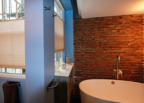 Master Bathroom Exposed Brick freestanding soaking tub chrome light blue