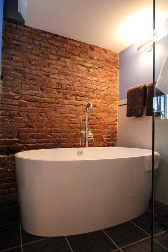 Master Bathroom Modern Soaking Tub exposed brick freestanding industrial 