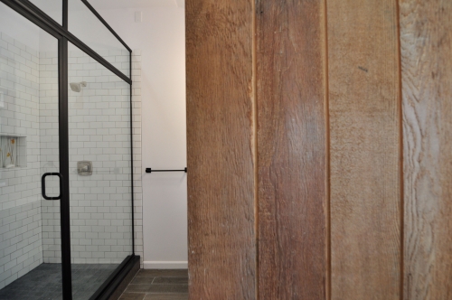 industrial shower door barn sliding door porcelain wood tile subway tile recessed storage niche black finished fixtures