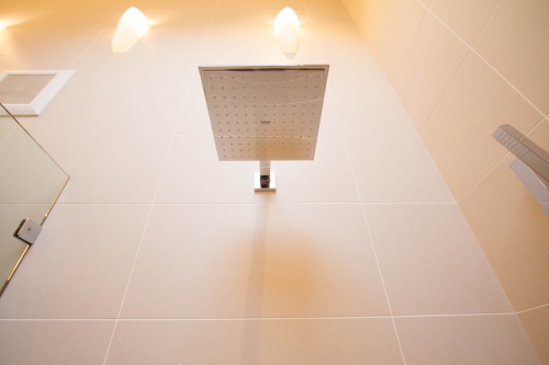 master bath remodel large format tile beige glass panel rainhead handheld shower