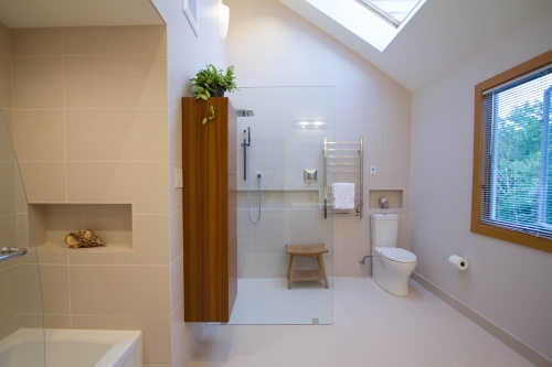 master bath remodel large format tile beige glass panel recessed niche skylight