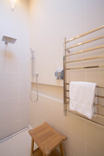 master bath remodel rainhead towel warmer curbless shower beige modern