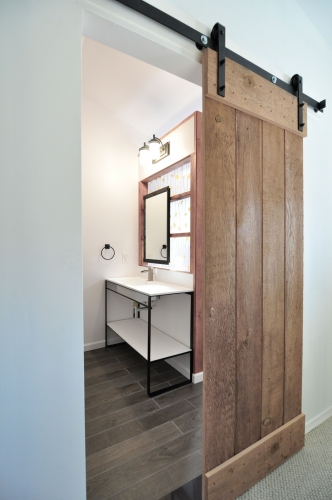 modern industrial bath sliding barn door console sink resin panel wood look porcelain floor tile