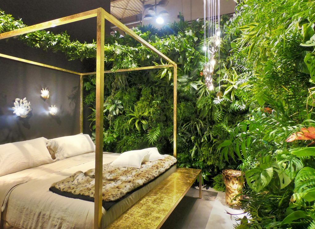 A bedroom exhibition uses different textiles and house plants to create different textures in the space

